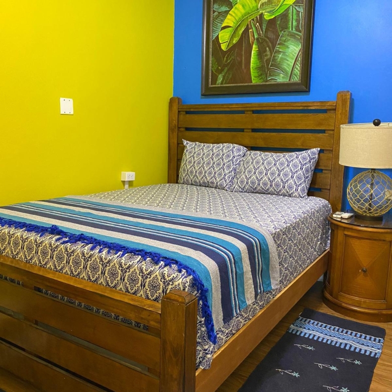 Furnished bedroom with double bed, bedside table and lamp in a 1 bedroom apartment for rent at Crescent Hill, Basseterre, St. Kitts