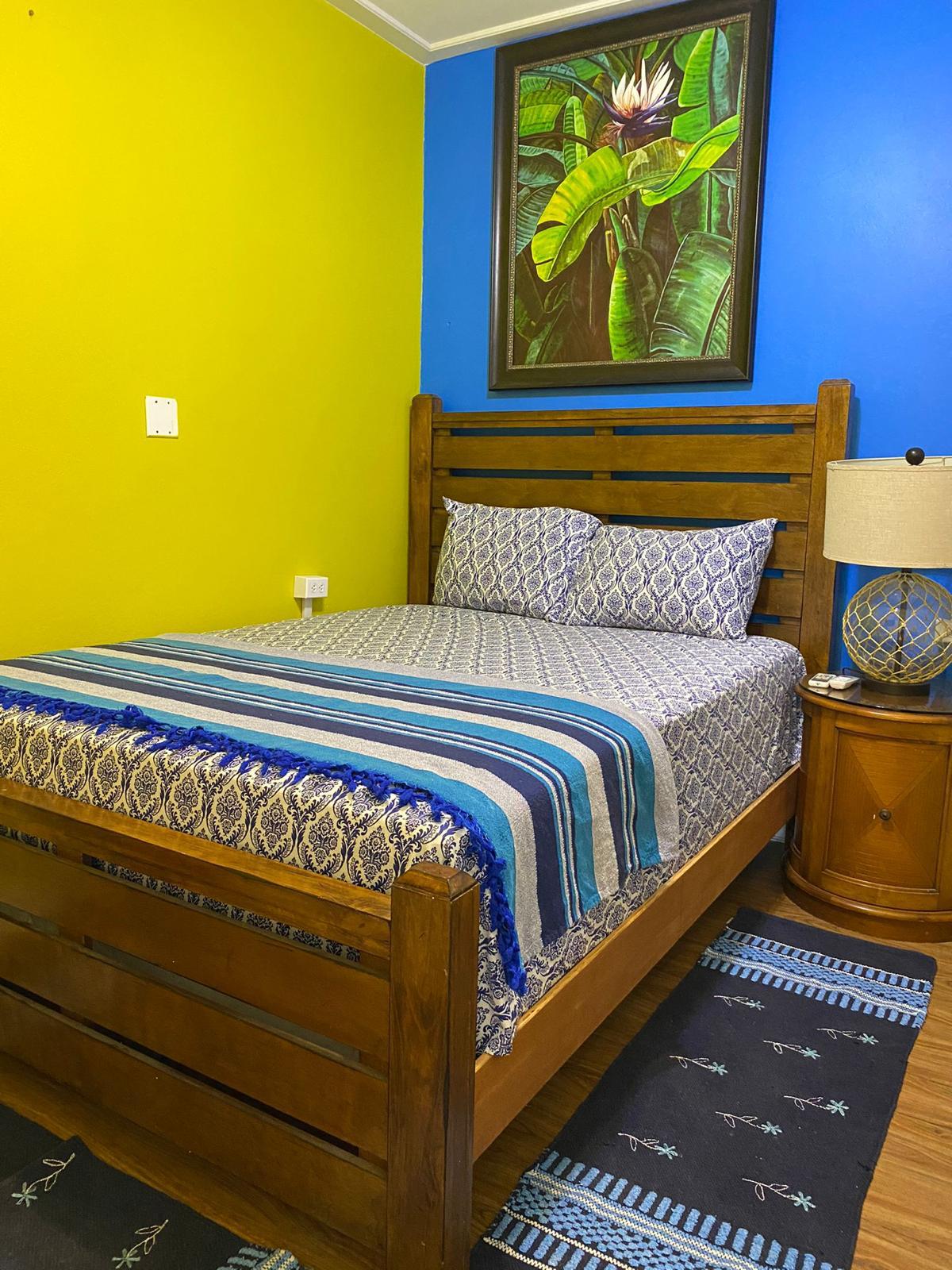 Bedroom Furnished bedroom with double bed, bedside table and lamp in a 1 bedroom apartment for rent at Crescent Hill, Basseterre, St. Kitts