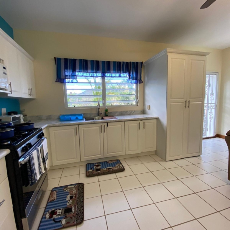 Fitted kitchen with gas range, marble worktops and pantry in a furnished 1 bedroom apartment for rent at Crescent Hill, Basseterre