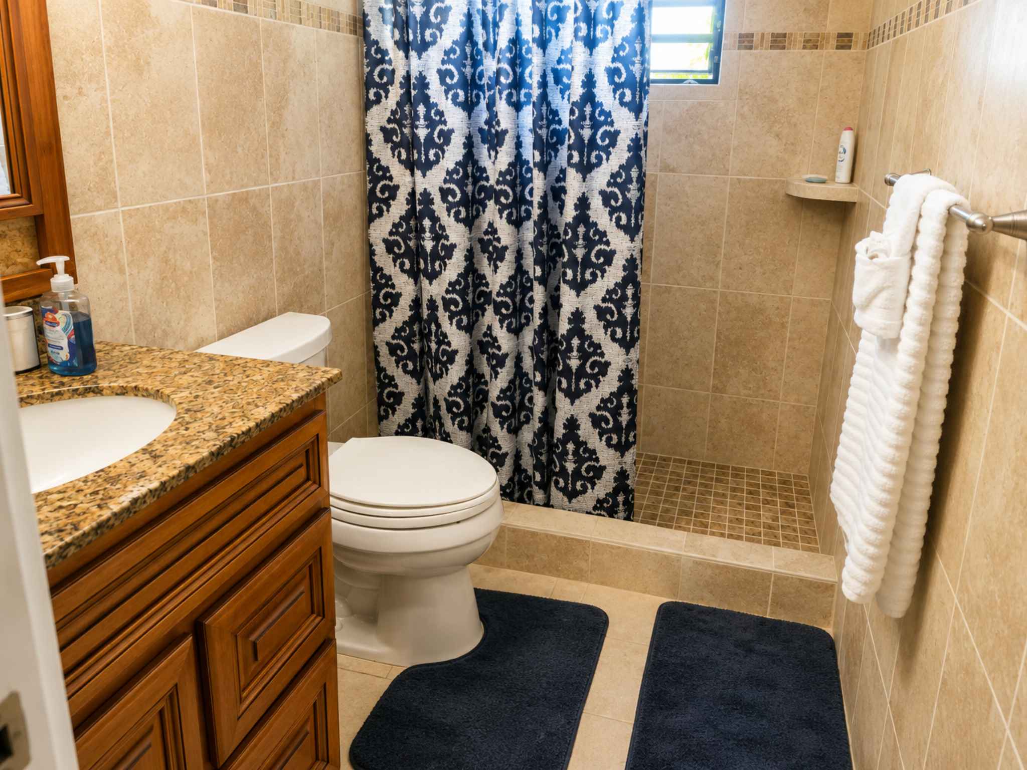 Bathroom with tiled shower, granite-topped timber vanity and framed mirror