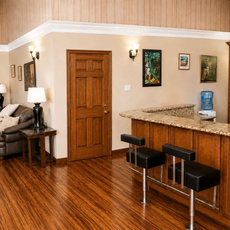 Granite breakfast bar with black stools separating the kitchen from the living area