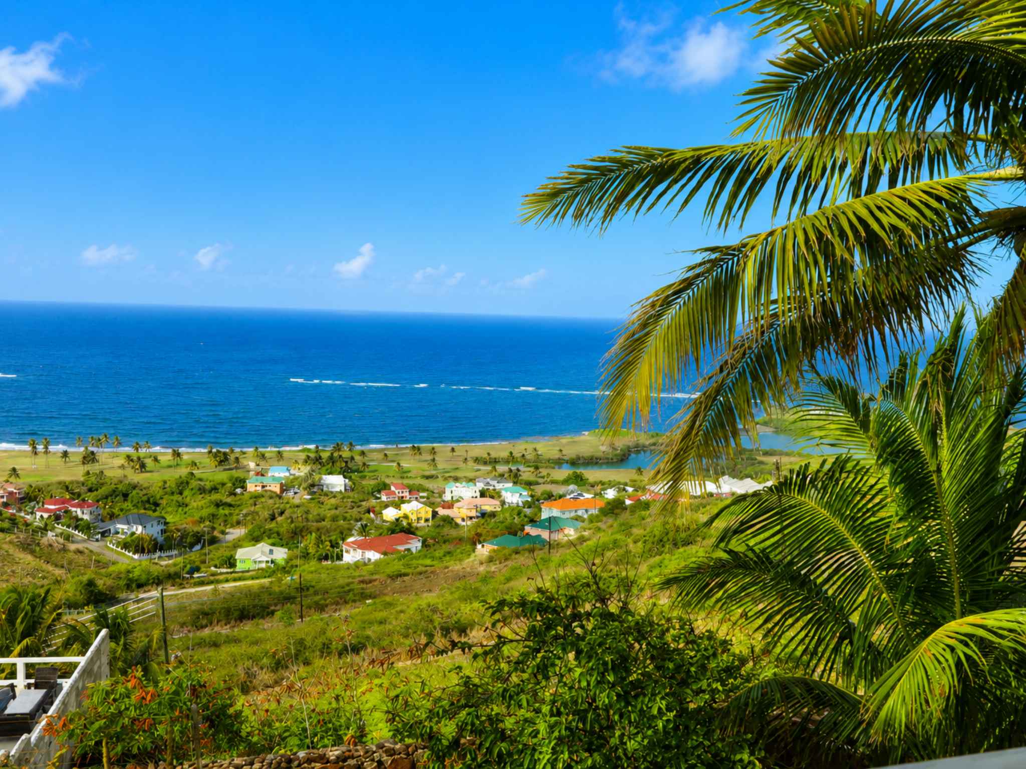 Unobstructed Atlantic Ocean view over green hillside and coastal village, seen from the property