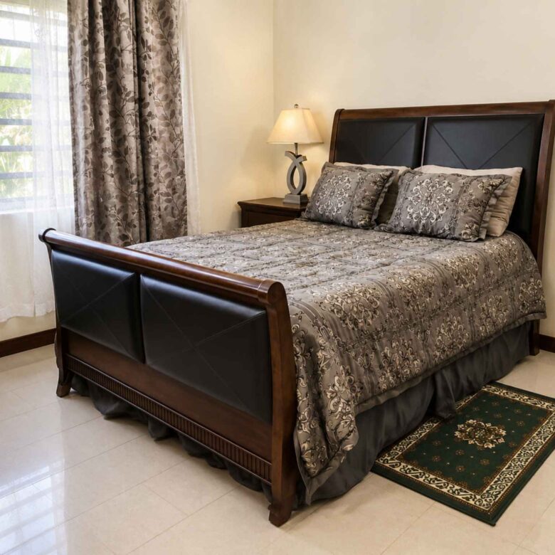 Second bedroom with a dark wood sleigh bed, tiled floor and curtained window