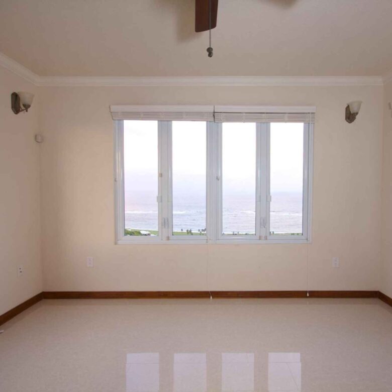 Empty room with windows on three sides framing the Atlantic Ocean and coastline