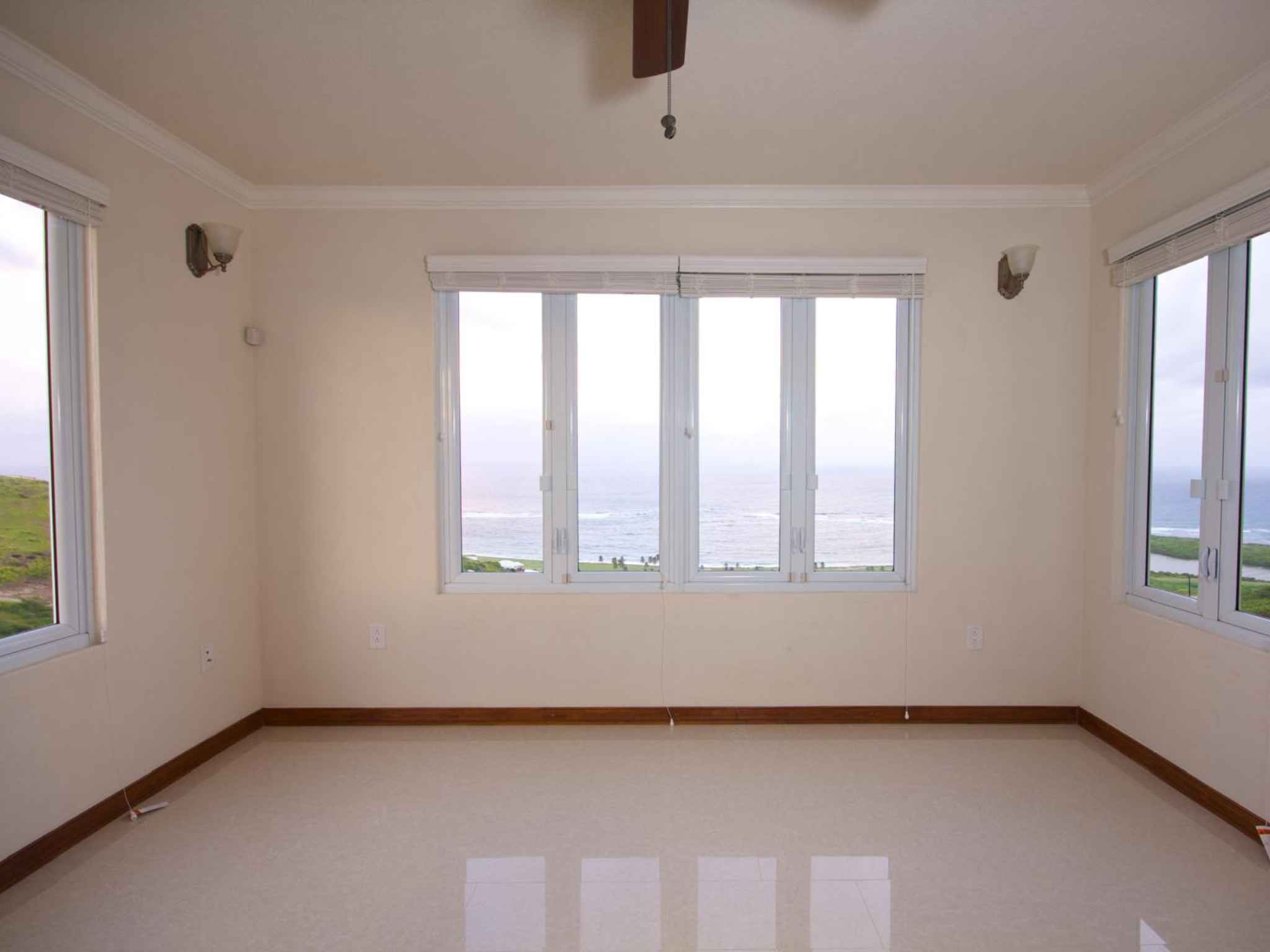 Empty room with windows on three sides framing the Atlantic Ocean and coastline