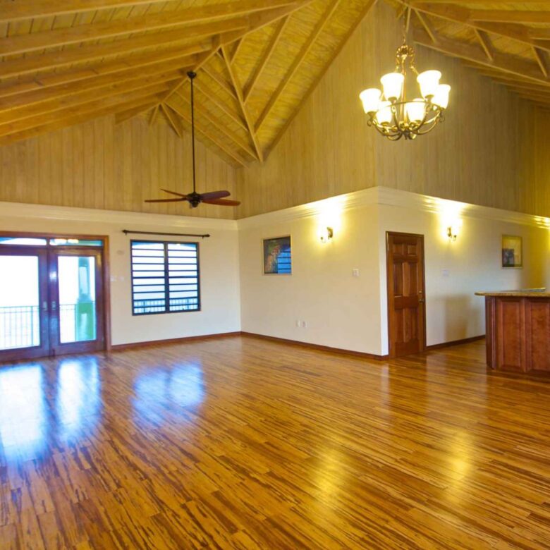 Open-plan great room with a high vaulted timber ceiling, exposed rafters and bamboo flooring