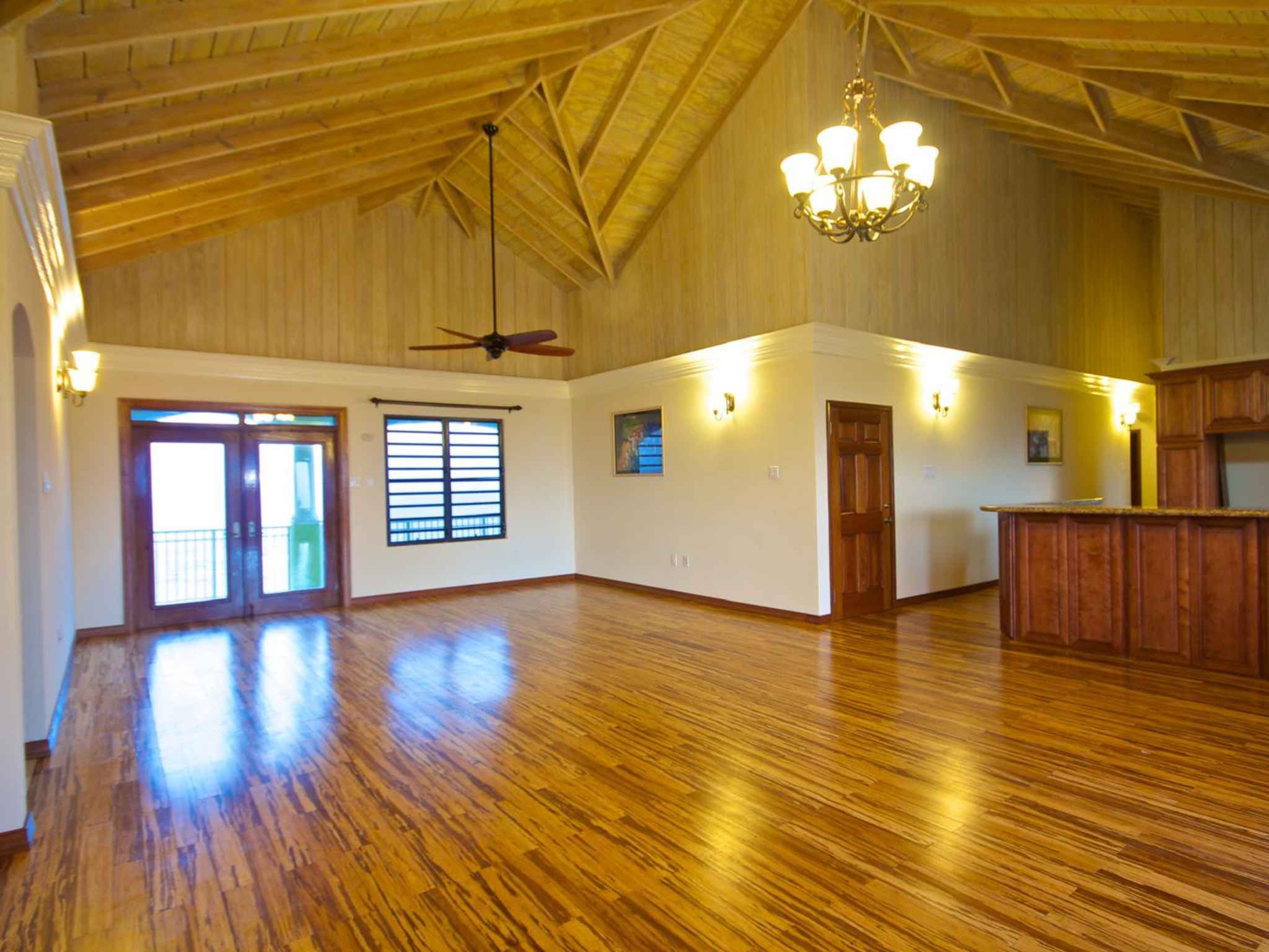 Open-plan great room with a high vaulted timber ceiling, exposed rafters and bamboo flooring