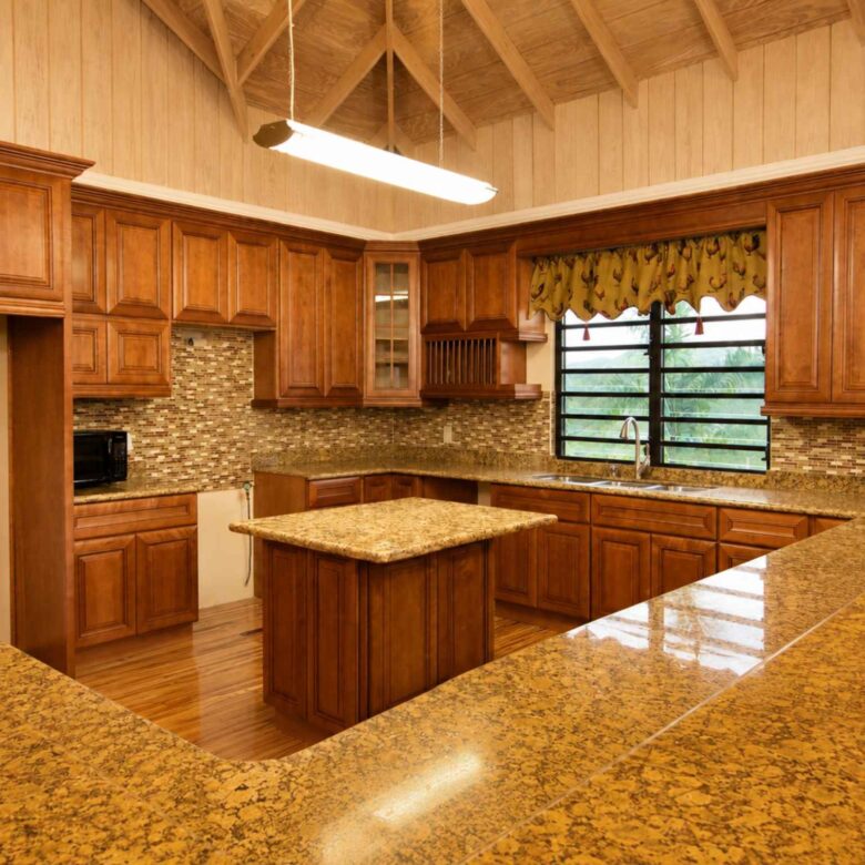 Wraparound timber kitchen with granite counters, central island and vaulted timber ceiling