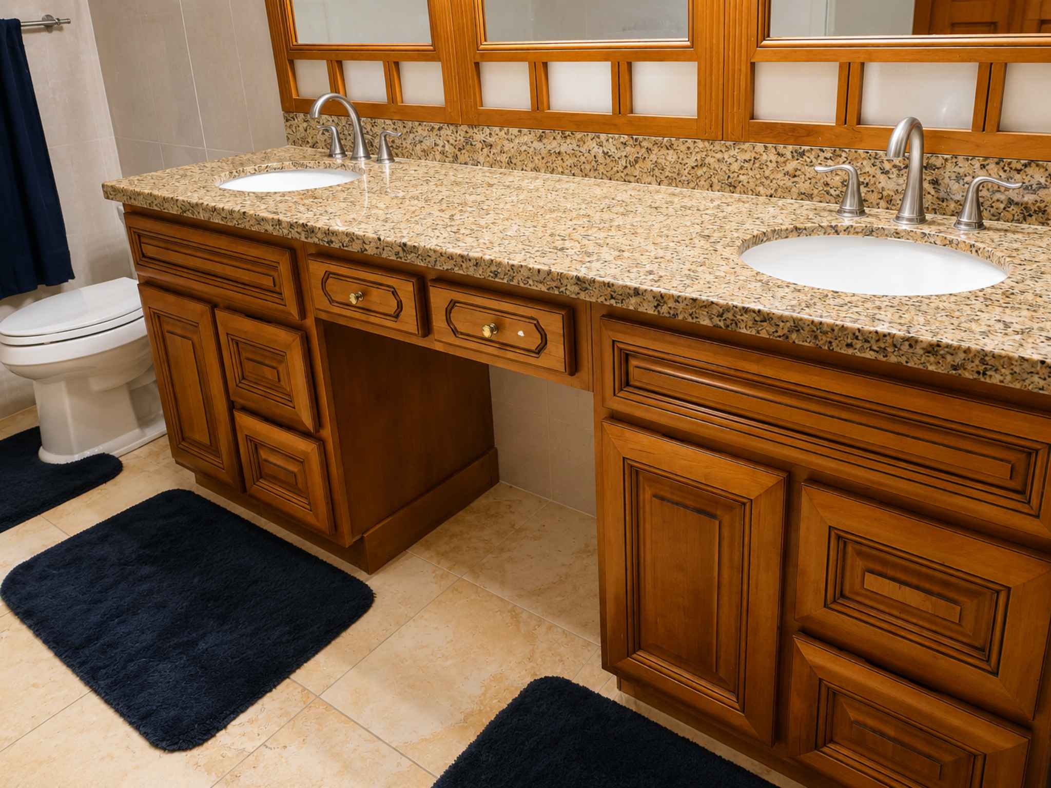 Primary bathroom double vanity with granite countertop, two basins and timber cabinetry