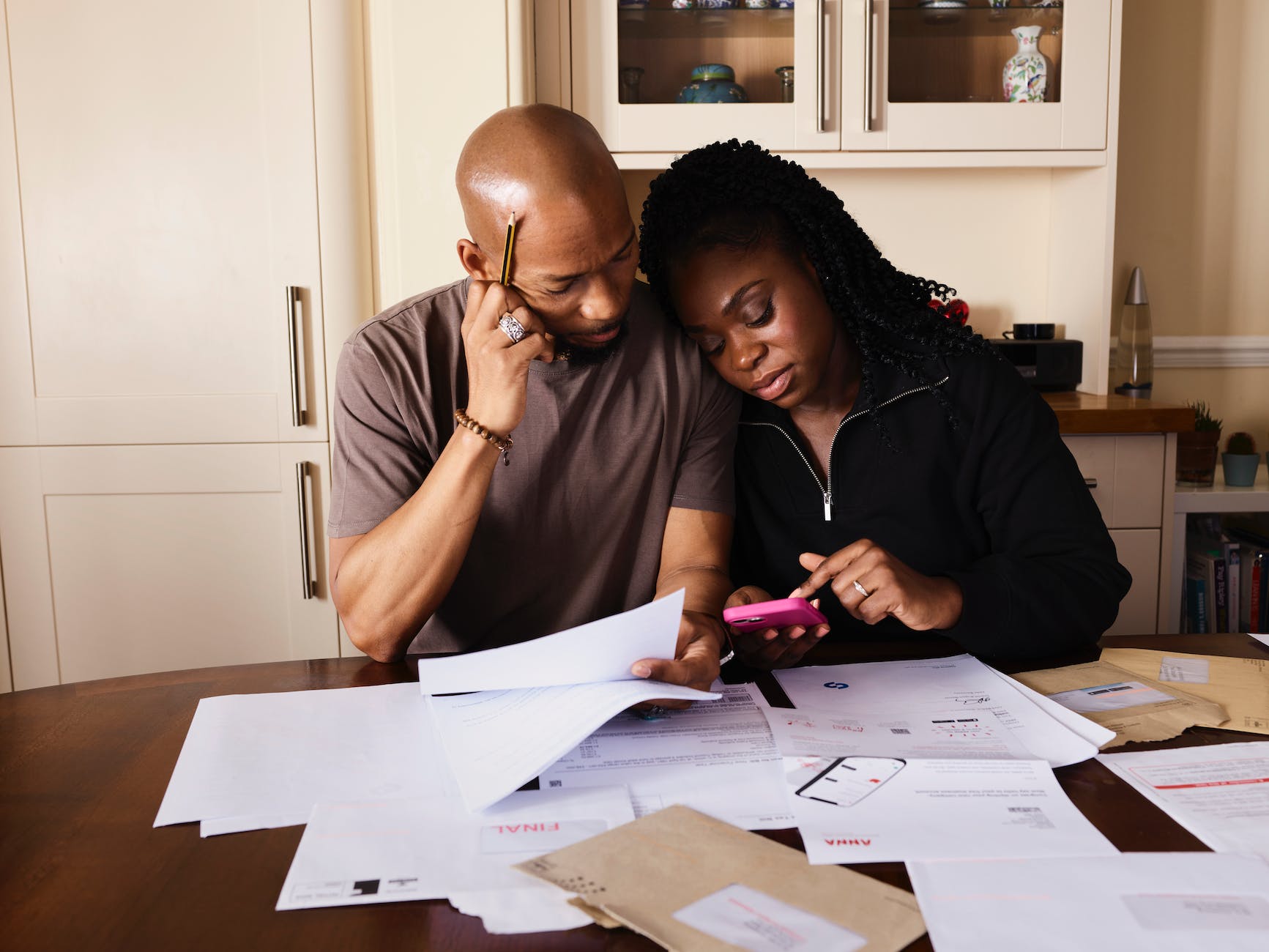 couple sitting by table calculating expenses